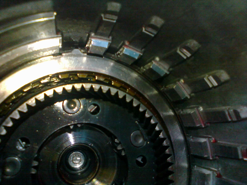 One more steel plate, then a span-ring goes around its circumference. One more friction, then this thick steel plate (called the pressure plate) gets locked down with another snap-ring.